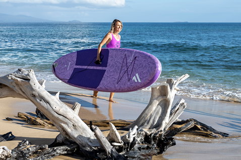 Fanatic Diamond Air Pocket inflatable SUP board 10'4" in purple carried at a tropical beach