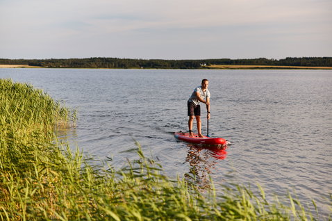 Duotone Fly Air inflatable SUP board during stand-up paddling on a calm lake