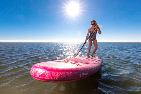 Fanatic Diamond Air inflatable SUP board during stand up paddling on flat water in pink