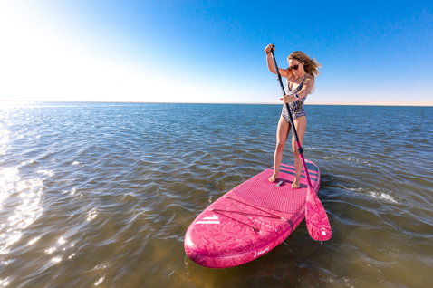 Duotone SUP Diamond Air inflatable SUP board during stand-up paddling on flat water in pink
