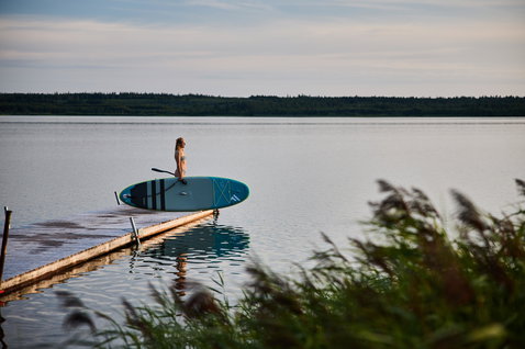 Duotone Fly Air aufblasbares SUP Board beim Stand Up Paddling an einem ruhigen See