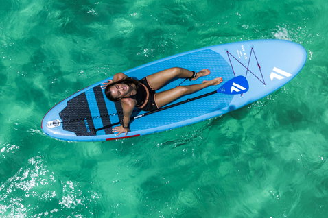 Duotone Fly Air inflatable SUP board in light blue during SUP on turquoise water