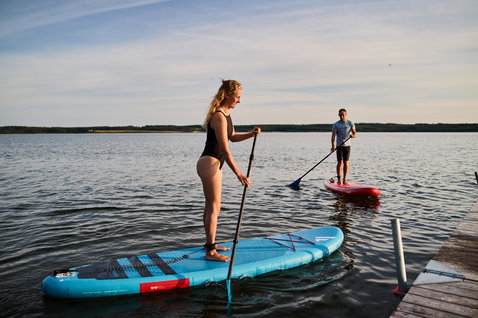 Duotone Fly Air inflatable SUP board during paddling on a calm lake in summer