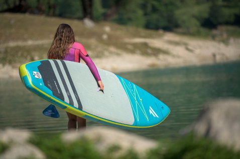 Fanatic Ray Air Premium aufblasbares Touring SUP Board in türkis und gelbgrün beim Stand Up Paddling am See