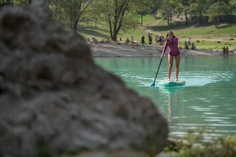 Duotone Ray Air Premium aufblasbares Touring SUP Board beim Stand Up Paddeln auf einem Bergsee