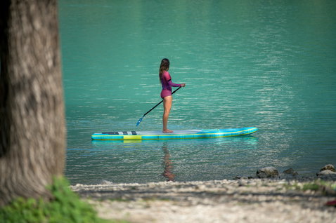 Duotone SUP Ray Air Premium aufblasbares Touring SUP Board beim Stand Up Paddling auf einem ruhigen See