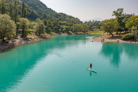 Duotone Ray Air Premium aufblasbares Touring SUP Board beim Paddeln auf türkisblauem Alpenfluss