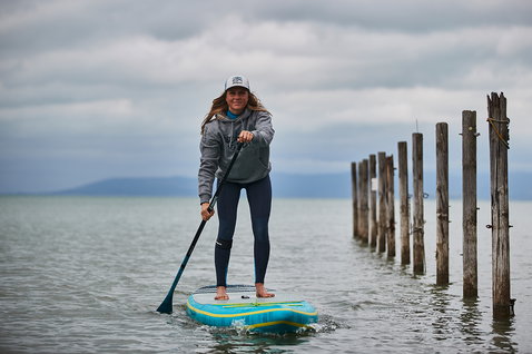 Duotone Ray Air Premium aufblasbares Touring SUP Board beim Stand-Up-Paddeln auf ruhigem Wasser