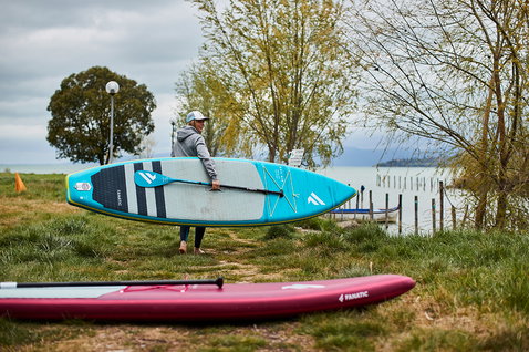 Fanatic Ray Air Premium aufblasbares Tourenboard in türkis beim SUP-Paddeln an einem See