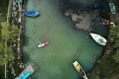 Fanatic Falcon Air Premium inflatable SUP raceboard during paddling in a harbor from aerial perspective