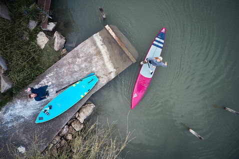 Fanatic Falcon Air Premium inflatable SUP raceboard in pink during stand-up paddling at a river dock