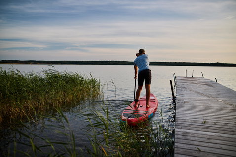 Duotone Ray Air aufblasbares Touring SUP Board beim Stand Up Paddling auf einem ruhigen See im Sommer