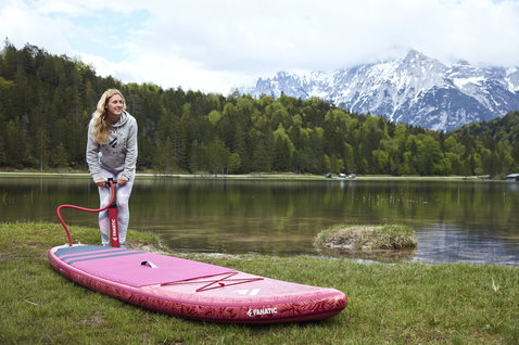 Duotone Diamond Air Touring iSUP 11'6" in raspberry being inflated at an alpine lake with mountain backdrop