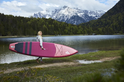 Duotone Diamond Air Touring inflatable SUP board during paddleboarding at an alpine lake with snowy peaks