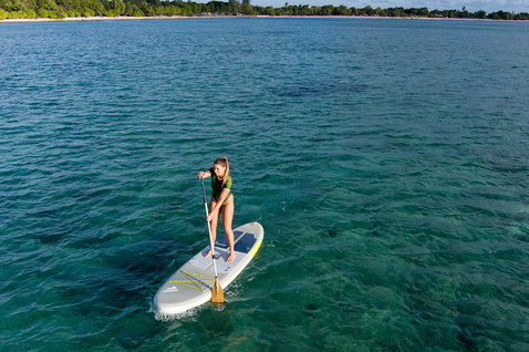 Fanatic Fly Air SLT inflatable SUP board during stand-up paddling in a tropical lagoon aerial view