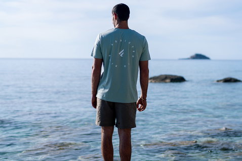 Fanatic SUP Tee unisex short-sleeve t-shirt in light blue with back logo print at the ocean