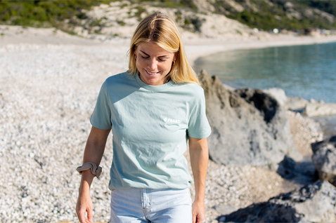 Fanatic SUP Tee unisex short-sleeve t-shirt in sage green worn at a rocky beach