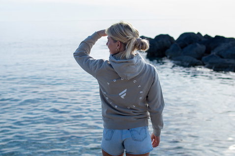 Fanatic SUP unisex hoodie in stone grey with ADDICTED back print at the ocean coast