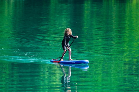 Fanatic Ripper Air SLT inflatable SUP board 7'10'' in blue during stand-up paddling on a mountain lake